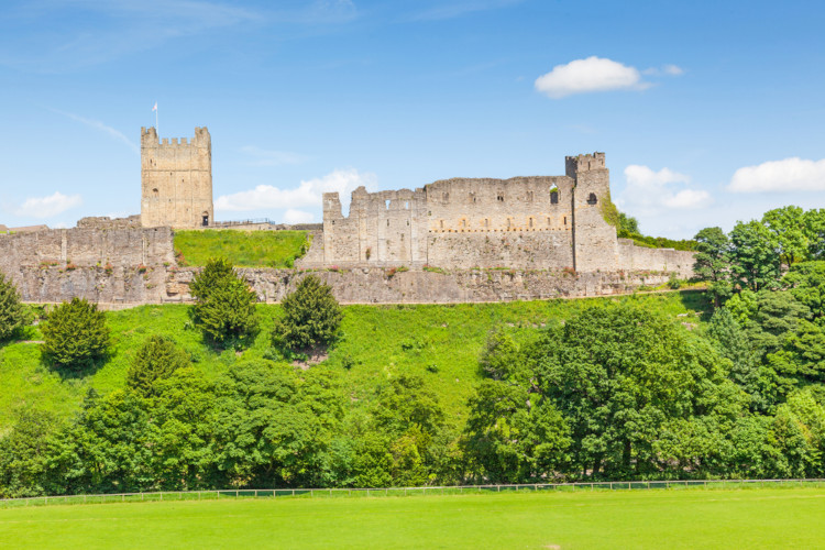 The remains of Richmond Castle on top of a green hill.